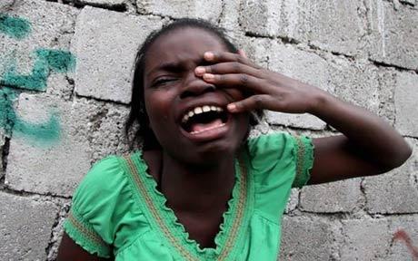 girl crying in rain. in Haiti, a girl cries.